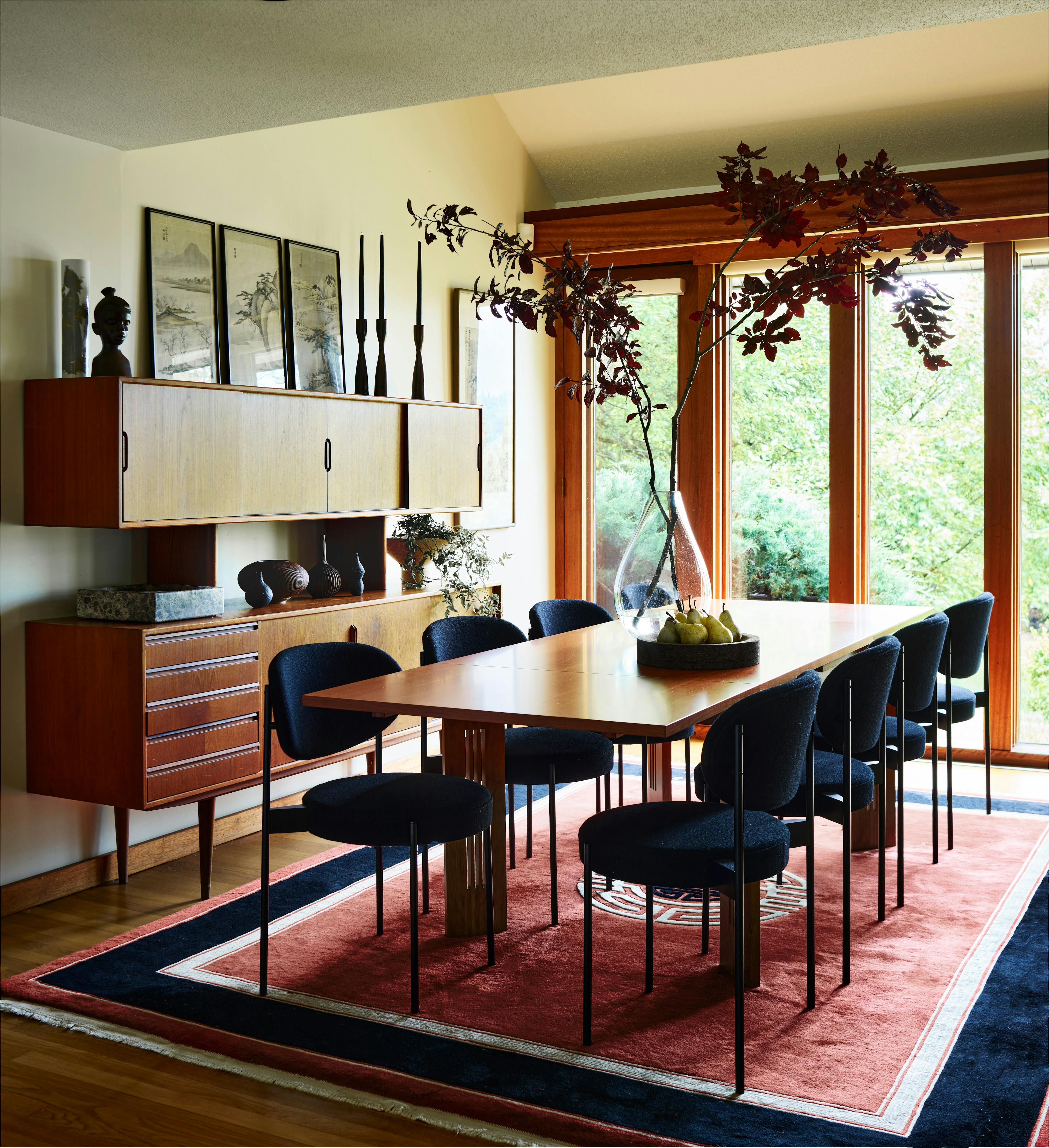 A dining room with a large table and chairs in the Amherst Residence, blending old antiques with contemporary pieces in a mountain landscape setting.
