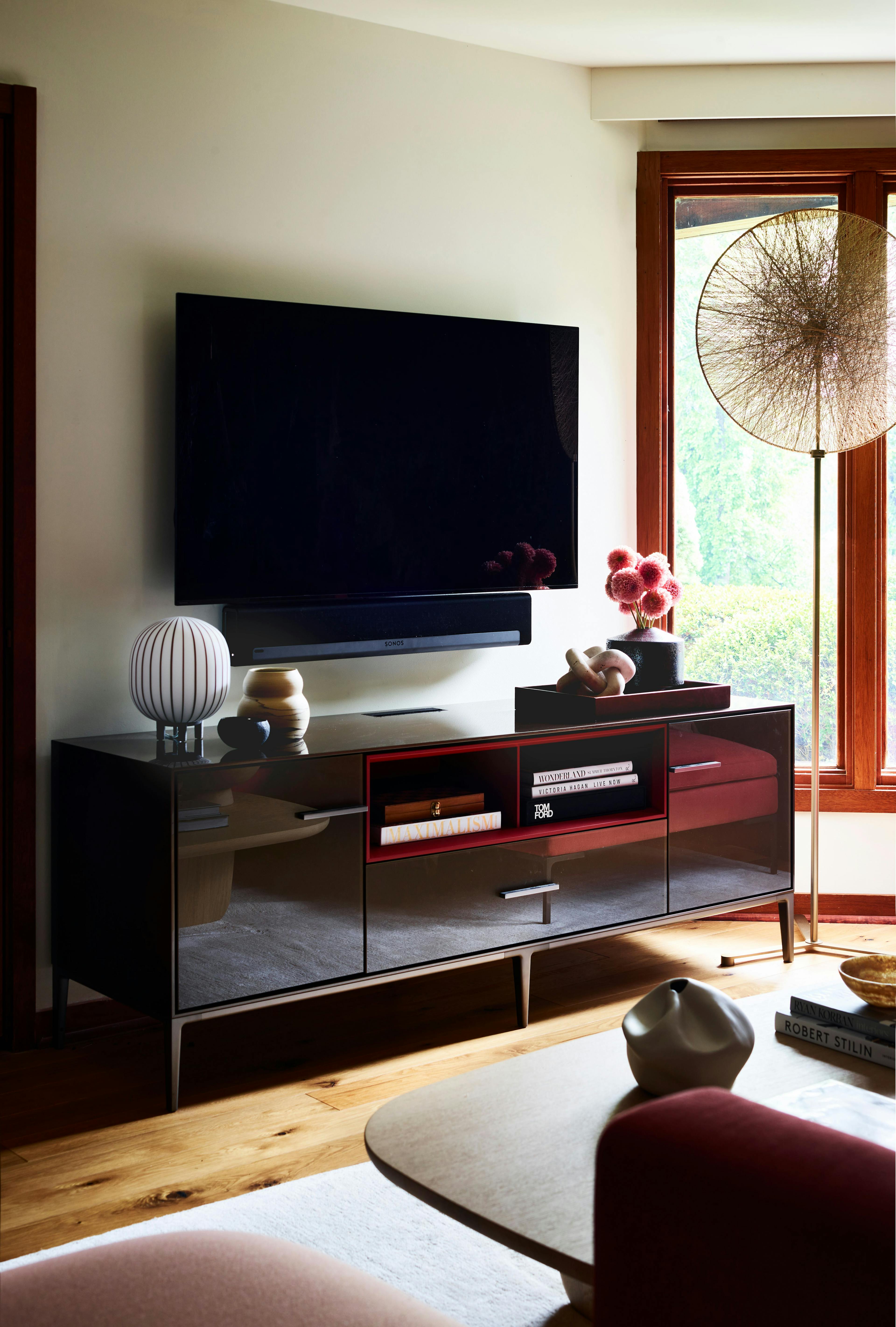 A modern entertainment center with a large flat screen TV in a room with a dynamic layout and stunning mountain views.