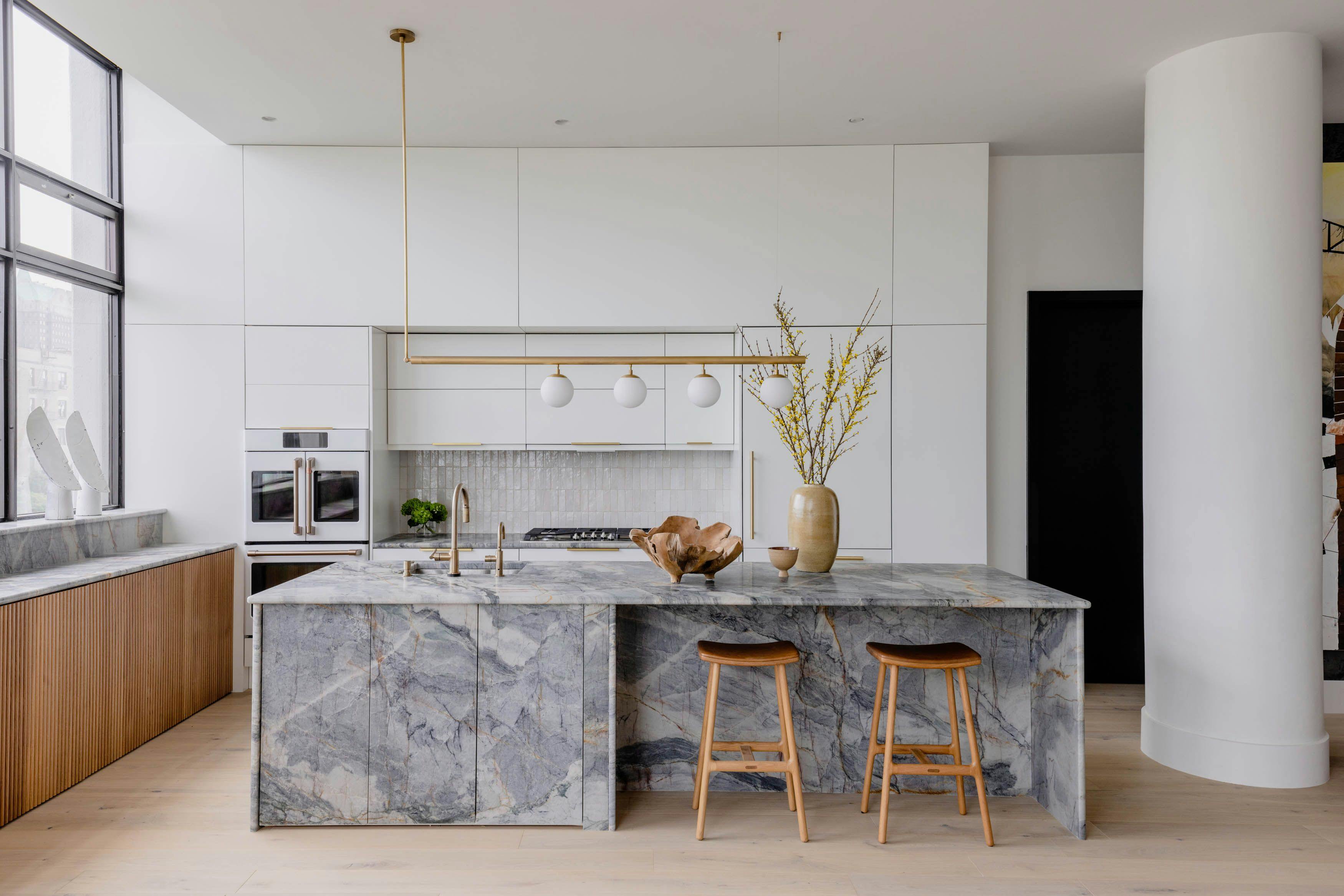 A modern space with minimalist design, warm wood accents, and a striking monolithic kitchen island.